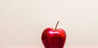 A red apple on an empty desk.