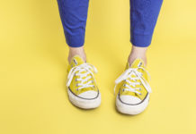 A pair of yellow converses against a yellow background.