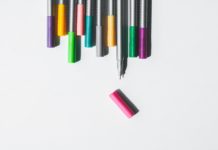 A row of coloured pens against a white background.